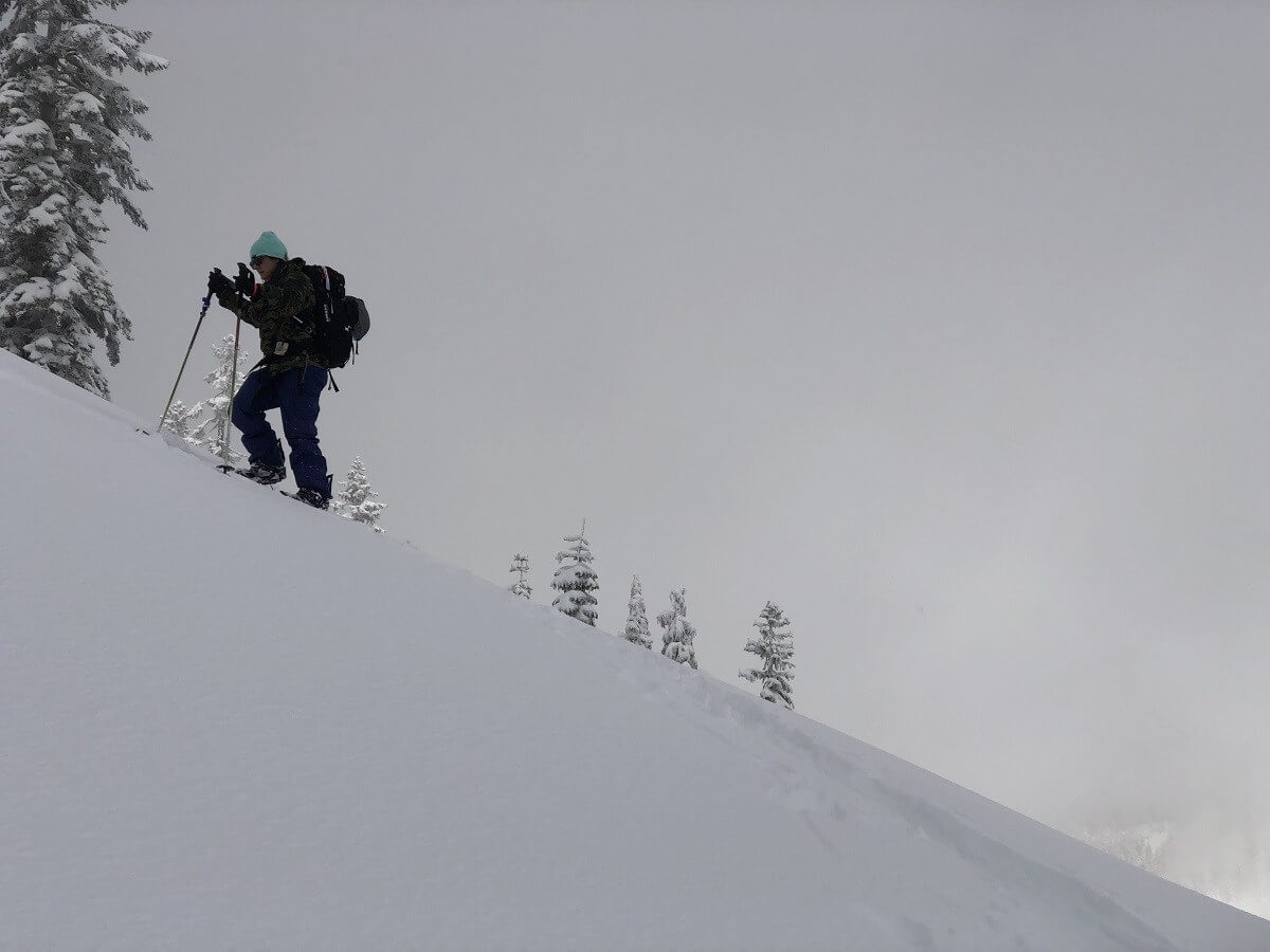 splitboarder climbing up a slope in Lassen National Park on a snowy day