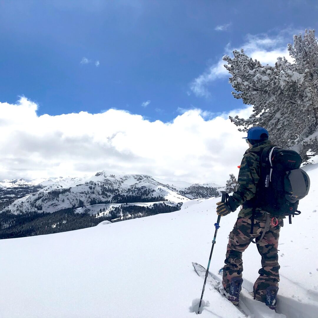 Splitboarder looking over Lake Tahoe backcountry snowboarding gear