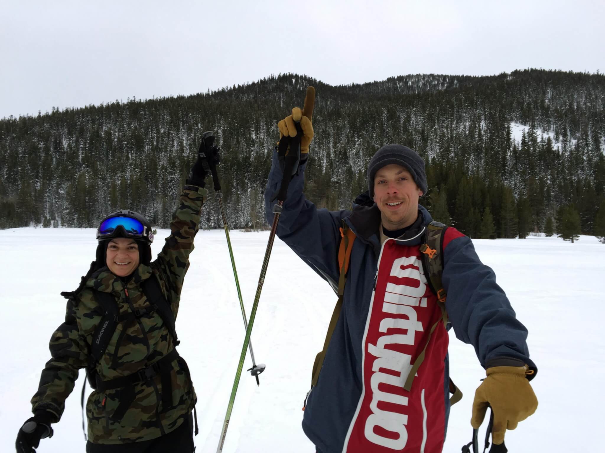 splitboarding 101 girl and guy intro to splitboarding in Lake Tahoe pointing to peak