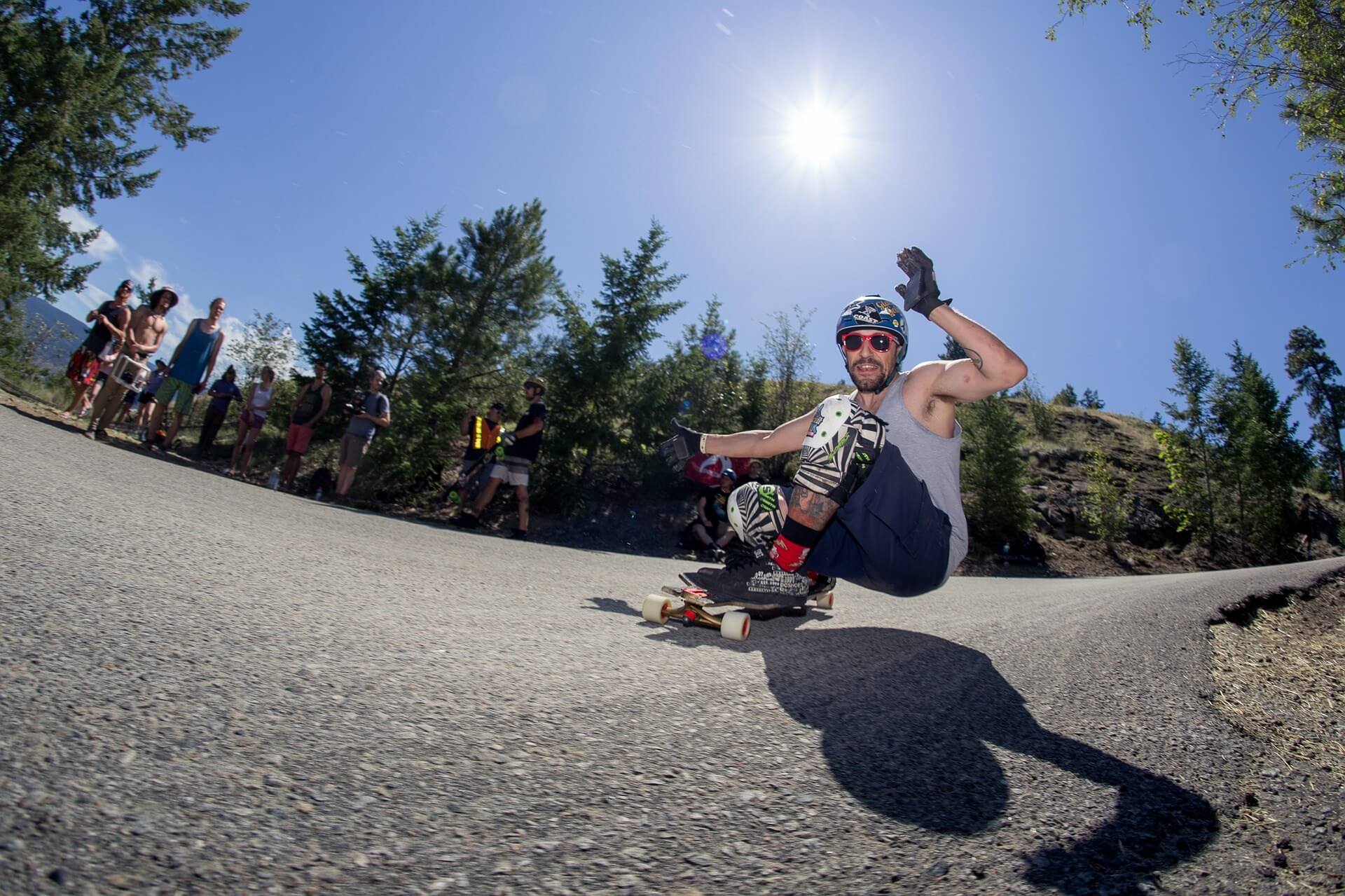 person longboarding on a downhill road