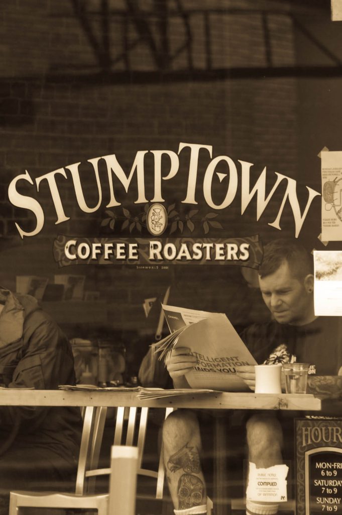 Guide to Mt Hood's Ski Resorts Person reading in front of Stumptown Coffee in Portland