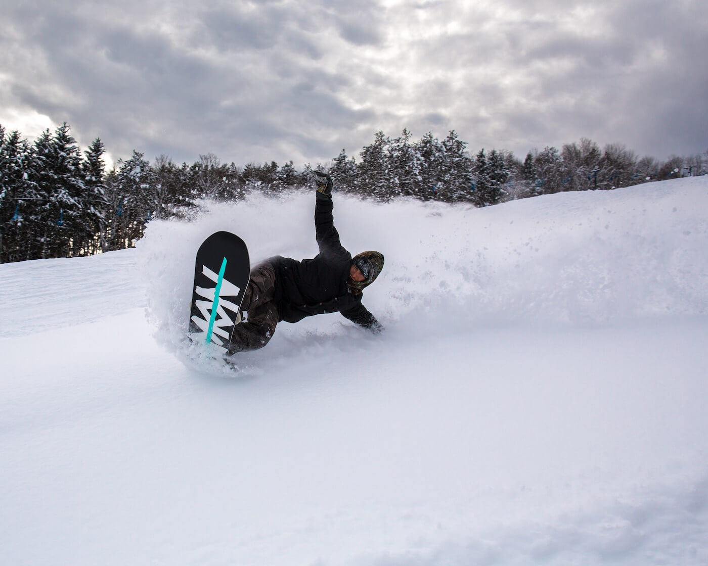 Snowboarder slashing powder at Snow Ridge in the snowiest ski resorts in upstate New York in a beautiful snow effect