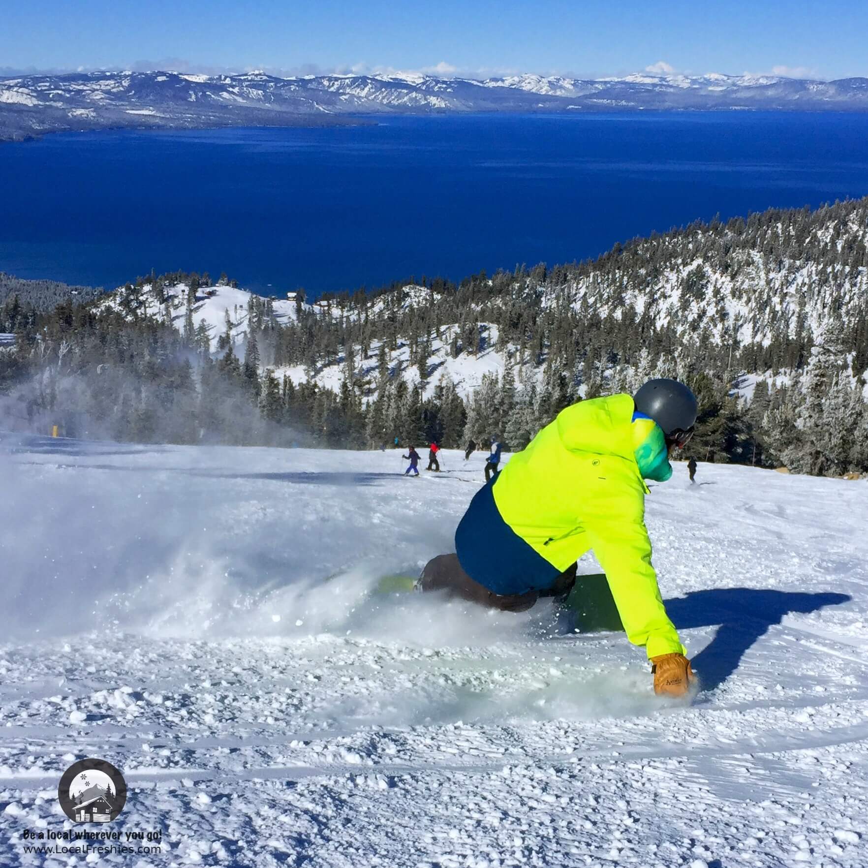 Snowboarder with bright yellow jacket making toe side turn at Heavenly Mountain