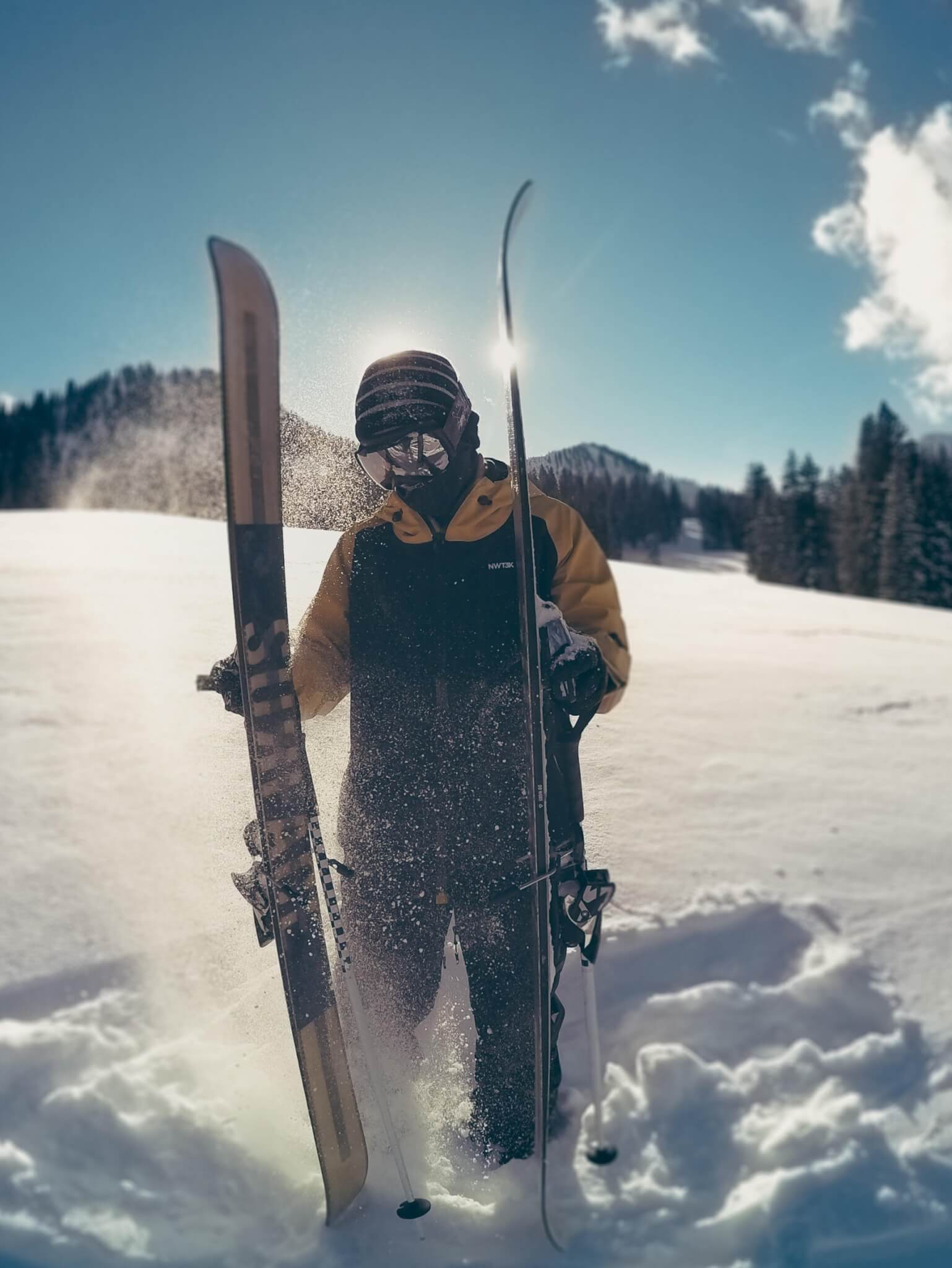 Skier slapping skis wearing NWT3K jacket made in USA