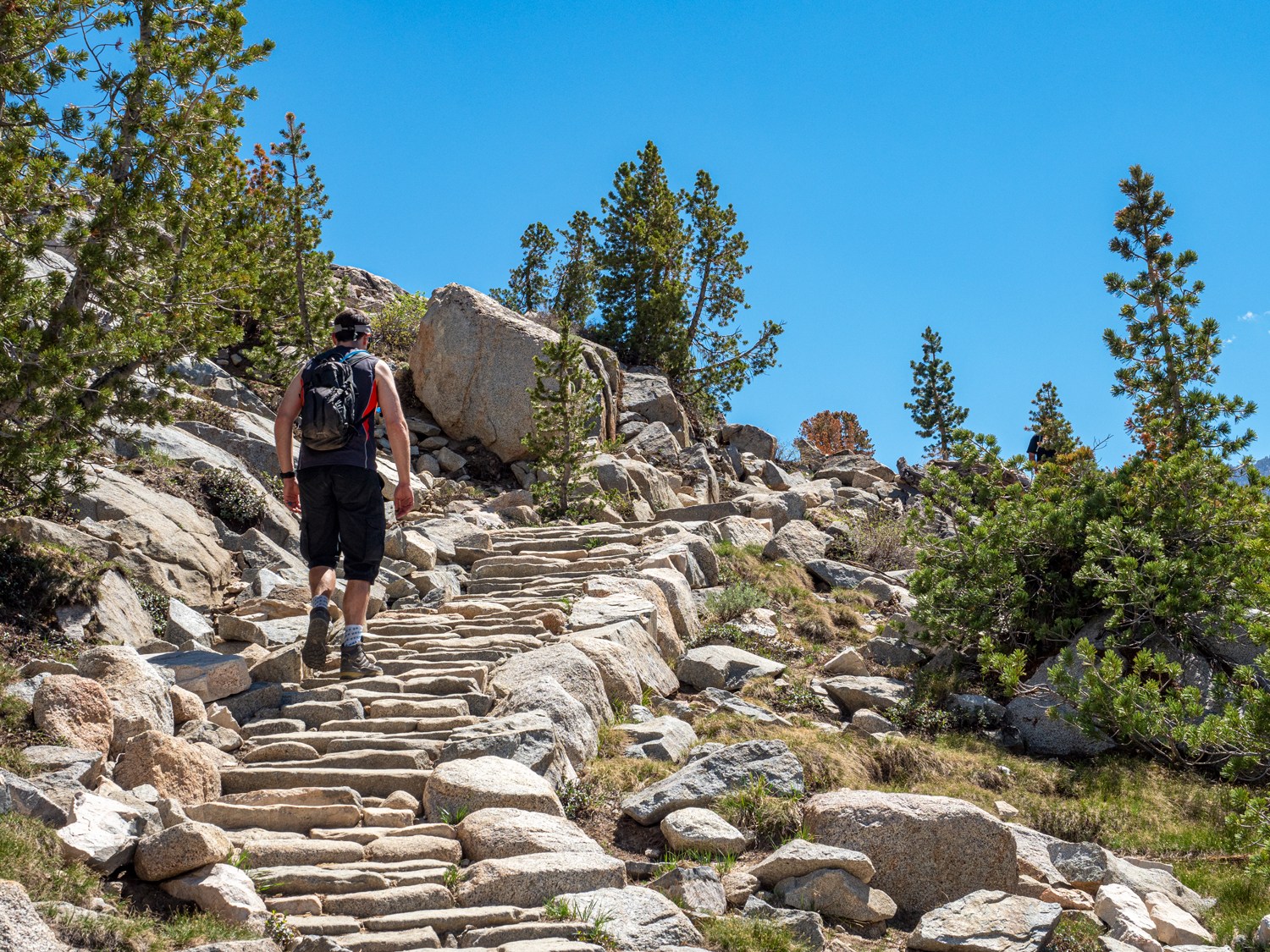 person walking up hand placed granite steps on their way to Blue Lake near Bishop California