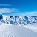 groomed corduroy-like snow at Soldier Mountain Ski Resort with the snow covered peaks of the Soldier Mountain range
