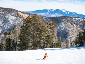 Snowboarder riding down Red River Ski Area