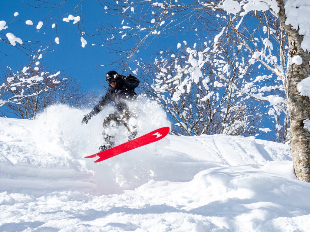 Snowboarder using Weston JaPow snowboard leaping into powder at Okunakayam Kogen Resort in Japan