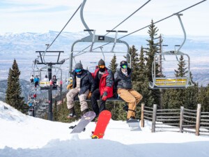 skiers on Tesuque chairlift at Ski Santa Fe on a sunny day