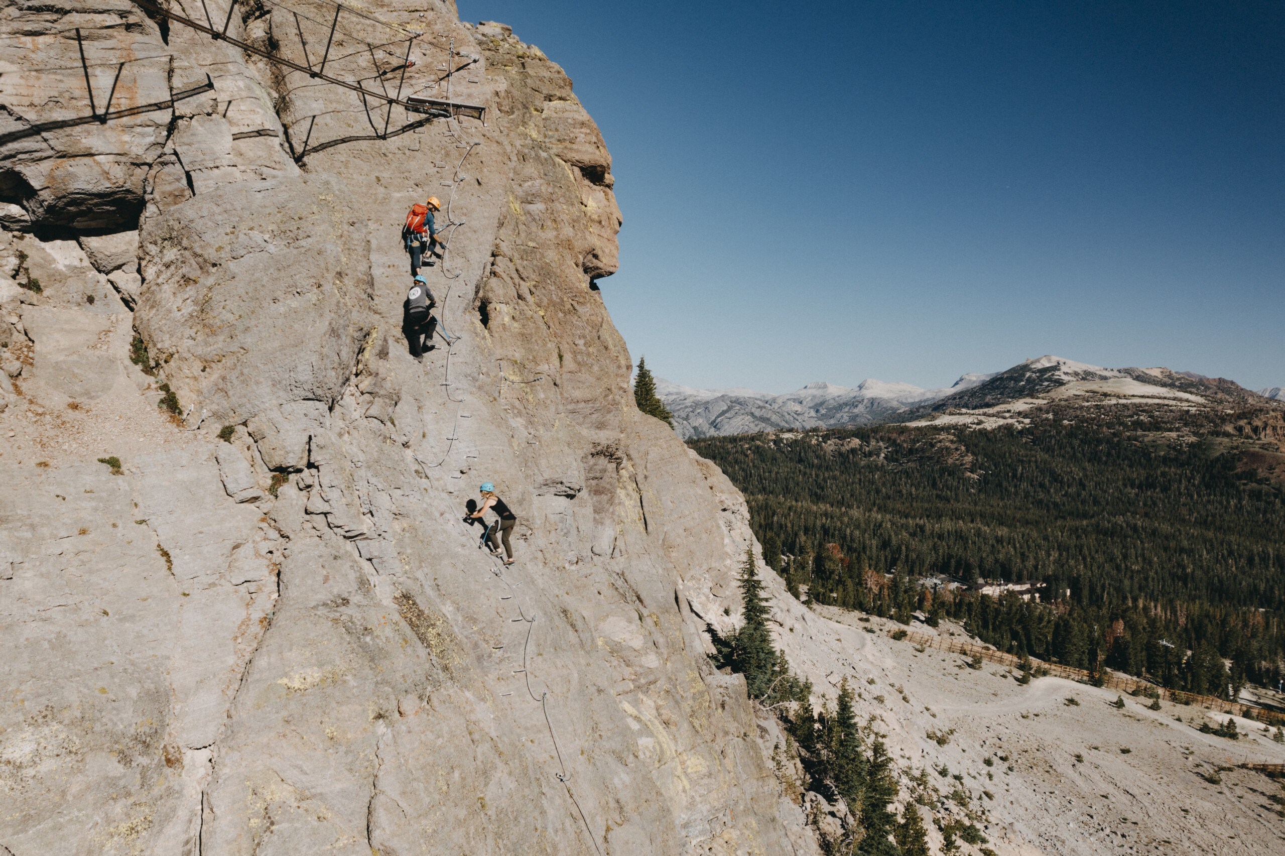 Rock climbers on the Mammoth Via Ferrata looking out at the terrifying Eastern Sierra in the summer