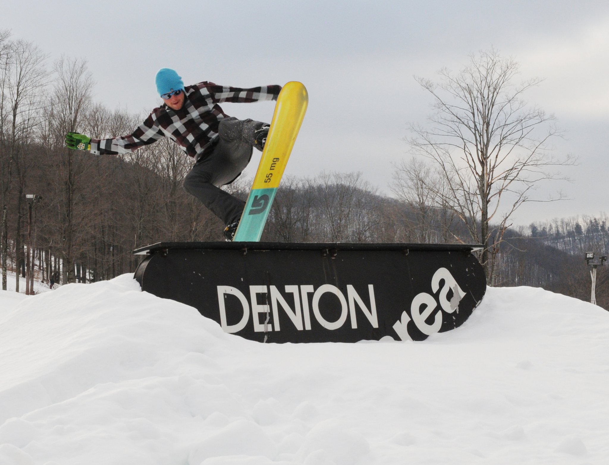 snowboarder doing a tail stall on a rail at Denton Hill Ski Area