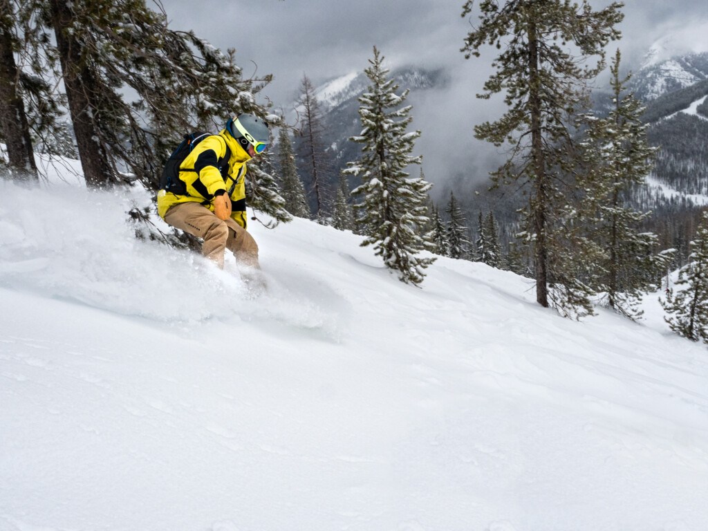 Snowboarder enjoying fresh powder on Eagle Peak at Lookout Pass Ski Area near Wallace Idaho