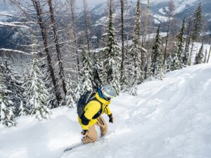 Snowboarder on Eagle Peak with mountains in the distance