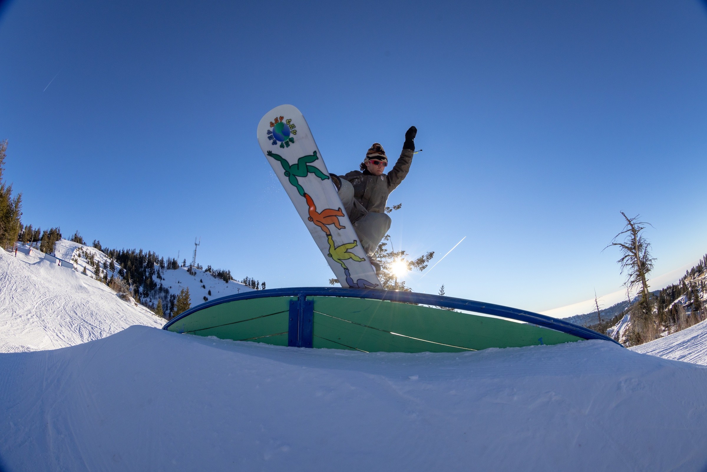 Adult Male Snowboarder Julian Gluck wearing red Sunglasses Nose Pressing a rainbowr ail in Bogus Basin Terrain Parks Towers