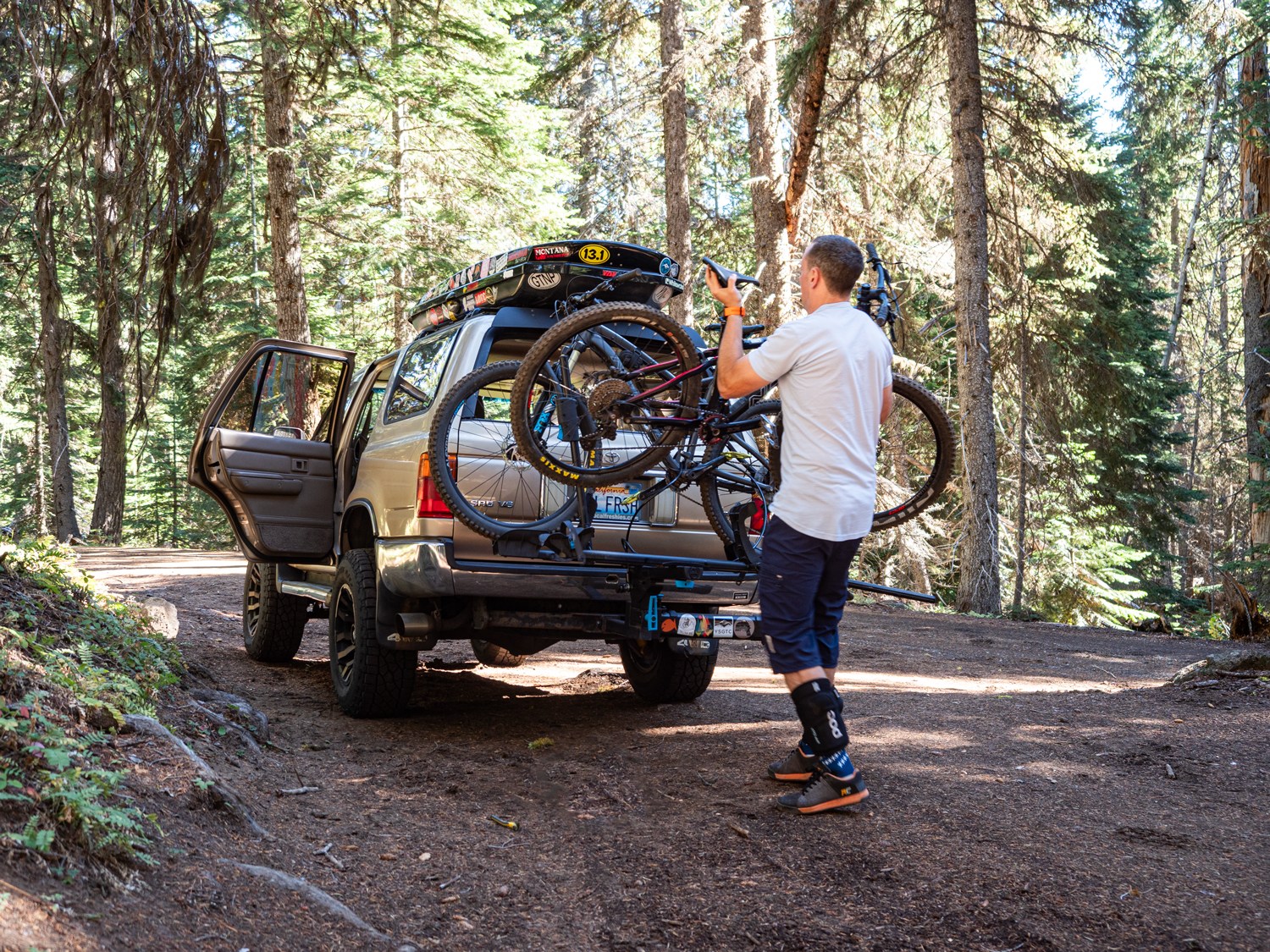 mountain biker taking off bike at 44 Trails trailhead off of a 4Runner