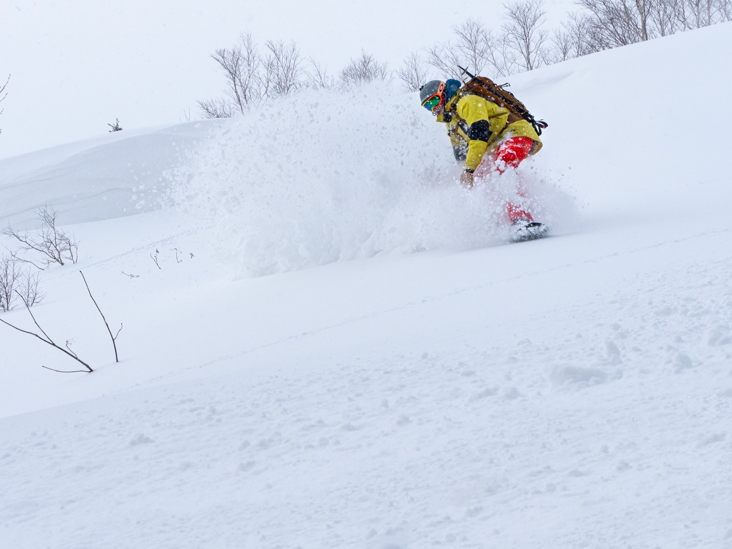 Snowboarder enjoying the deep powder at Hachimantai Cat Skiing in Japan