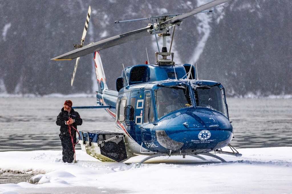 Helicopter used for Heli skiing at Silvertip Lodge waiting to take off for the day as it snows