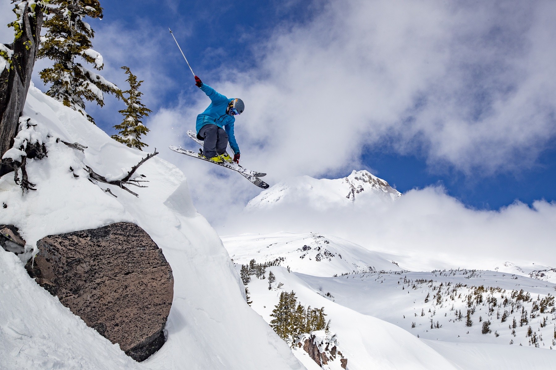 skier leaping into fresh snow with Mt Hood in the distance