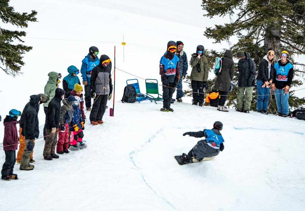 Snowboarder bombing down Banked Slalom Teton Surf Classic at Grand Targhee Resort