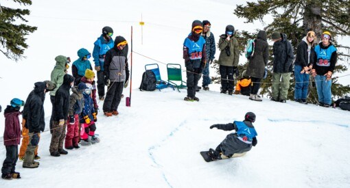 Snowboarder bombing down Banked Slalom Teton Surf Classic at Grand Targhee Resort