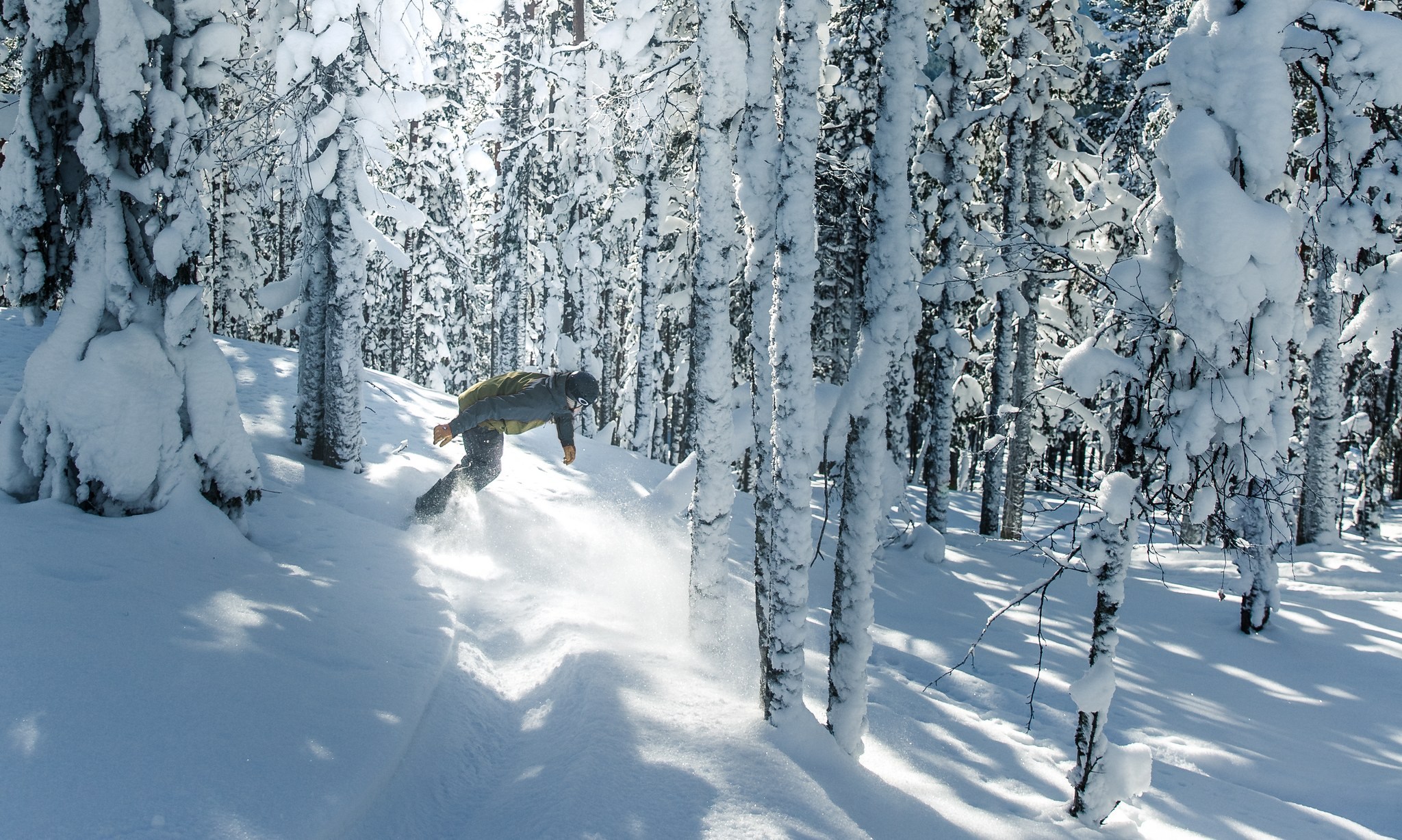 snowboarder riding through powder at Levi Ski Resort