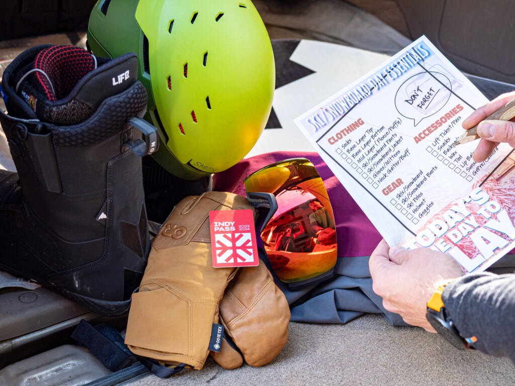 person using ski & snowboard checklist to make sure they everything for their day snowboarding
