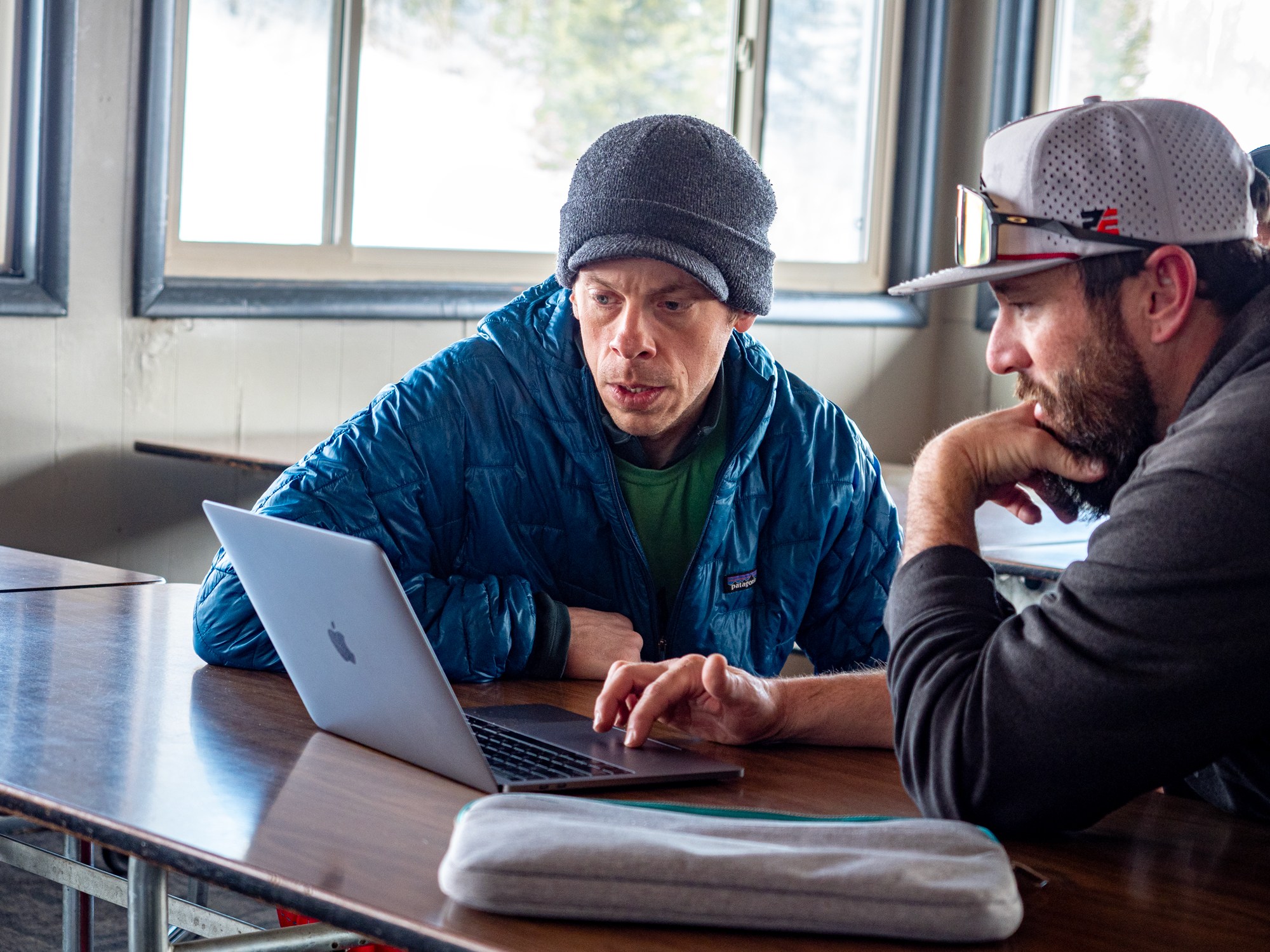 Zack Alexander looking at a computer with Alex Silgalis