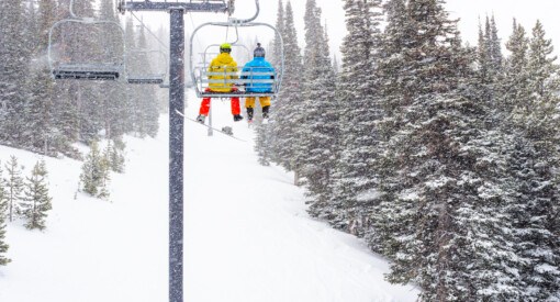 A skier and snowboarder on the main lift at Pomerelle Ski Area