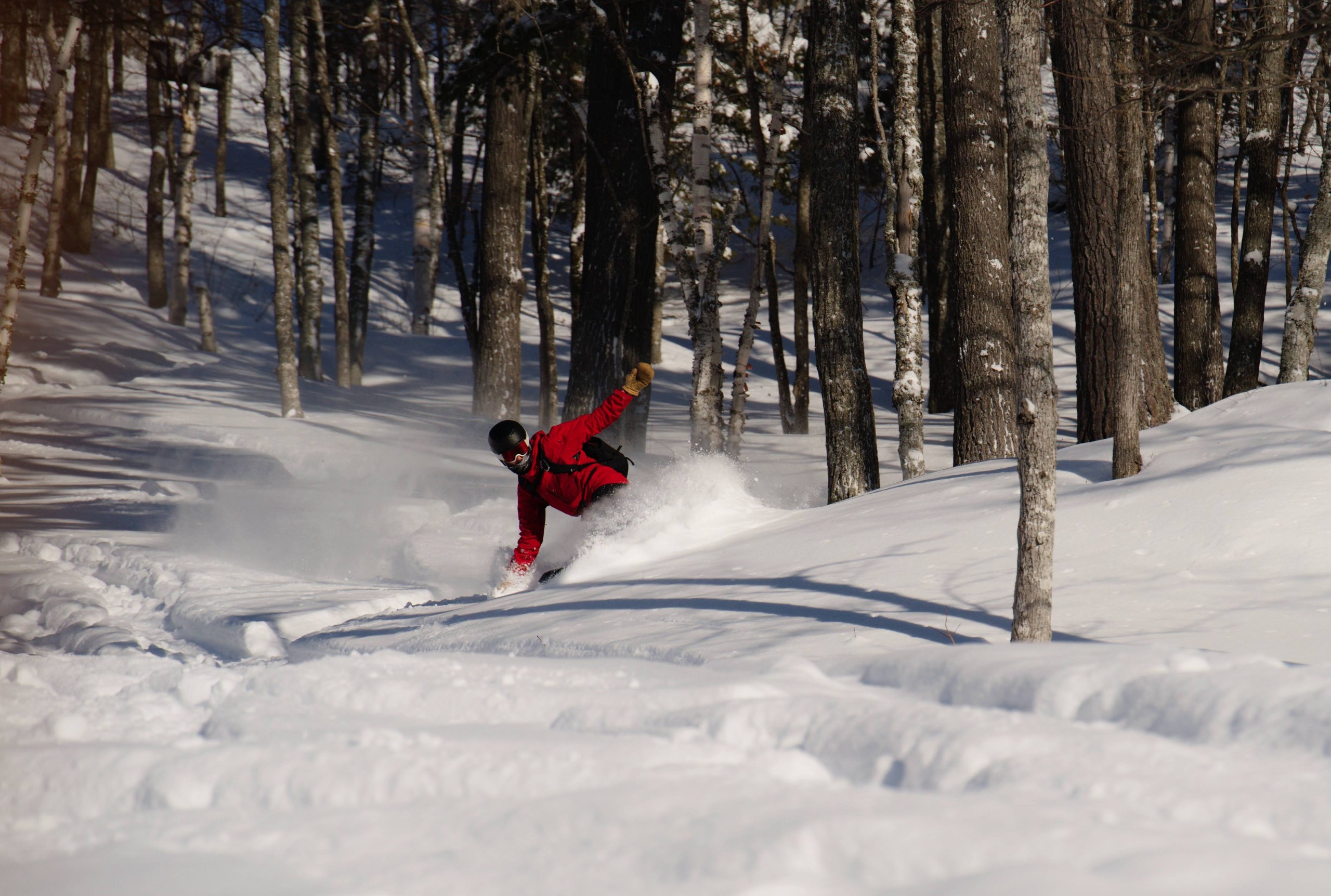 snowboarder slashing a pow turn in the Michigan Backcountry