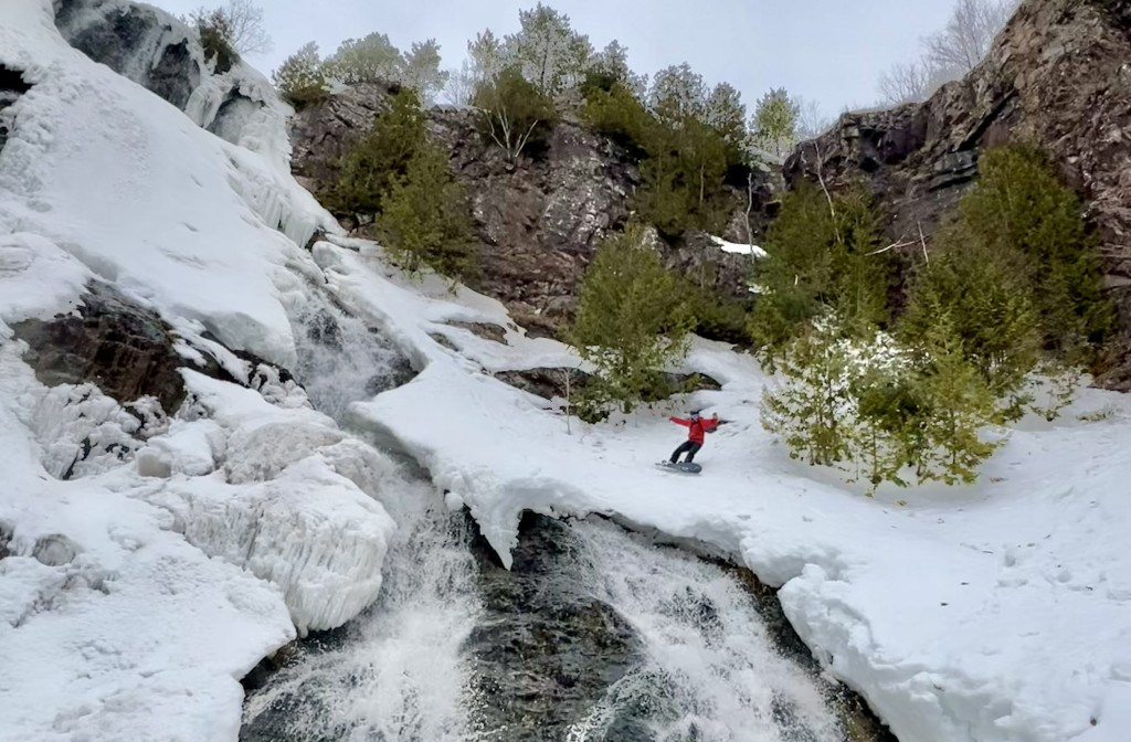 Snowboarder riding next to falls in Michigan