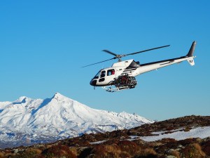 heli biking operation in New Zealand zipping across landscape with bikes on the helicopter